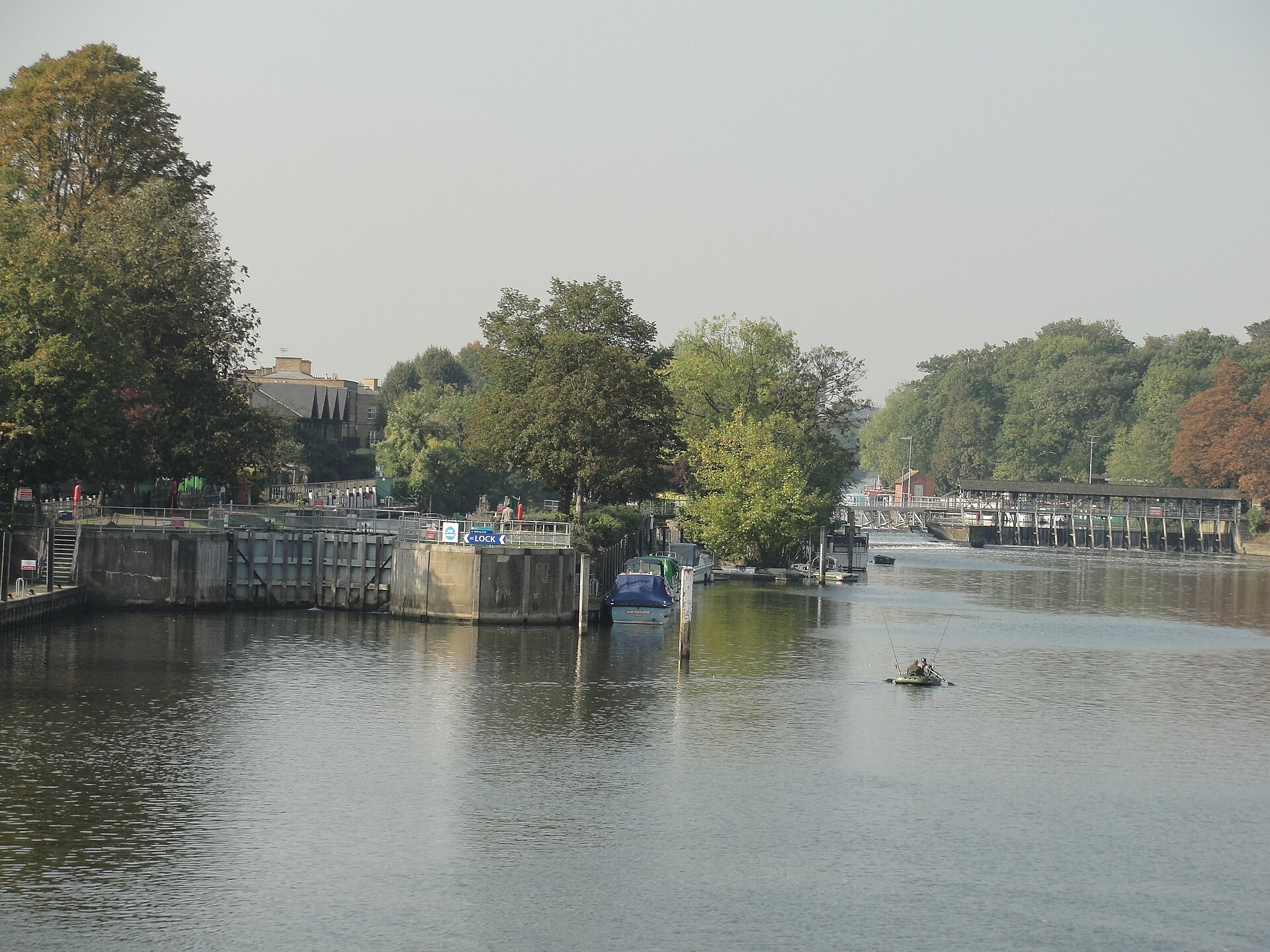 The Baroque front of Hampton Court Palace viewed along a gravel avenue between clipped yew trees